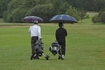 Golfspieler auf dem Platz mit Schirm